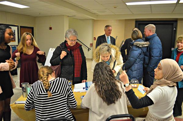 Students welcome residents of Hershey's Mill to the community breakfast. 